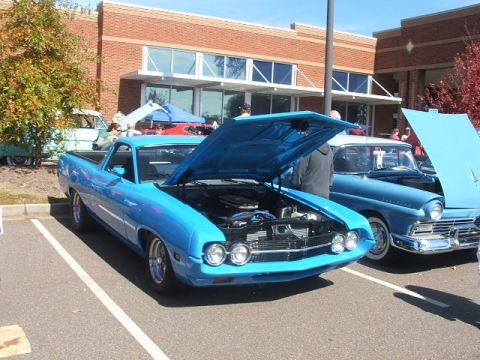 1971 Ford Ranchero - A blue Ford Ranchero from the early 1970s is displayed with its hood up at an outdoor car show.