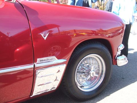 1971 Ford Ranchero - Chrome trim and wire wheel on a red car's fender, with 'Ranchero' script visible.