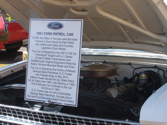 1961 Ford Patrol Car information sign next to engine bay. Sign details car's history and specifications
