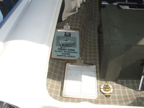 1971 Ford Ranchero - A document from a pursuit school is displayed on a clipboard within a vehicle's trunk.