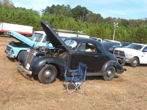 1971 Ford Ranchero - A vintage black coupe sits with its hood open, parked outdoors with other vehicles visible.