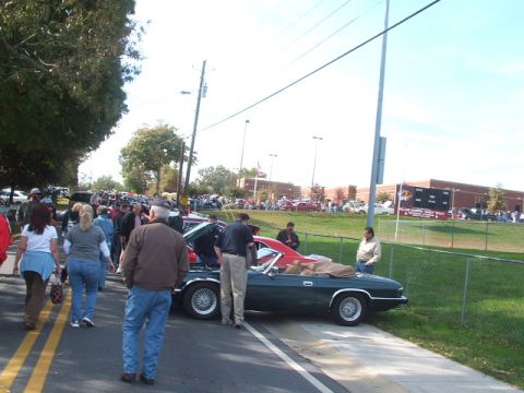 1971 Ford Ranchero - A dark green 1971 Ford Ranchero convertible with a red interior is displayed at an outdoor car show.