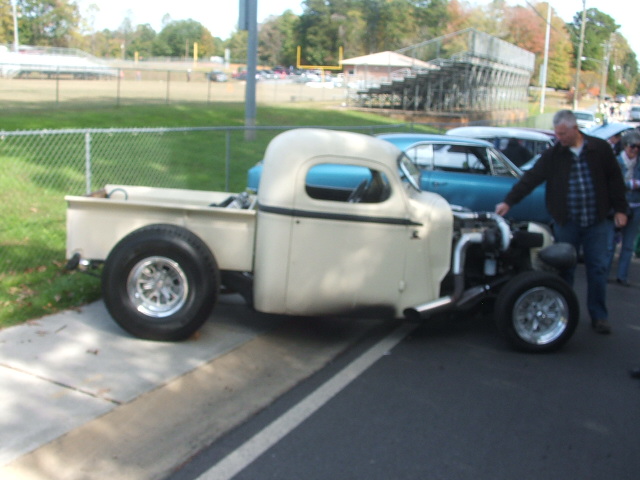 Cream custom pickup truck, side view, exposed engine, large rear wheels