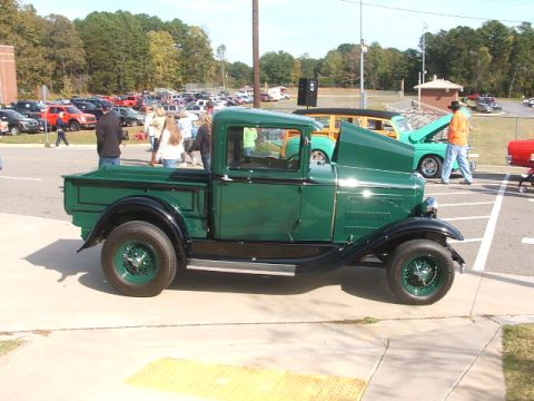 1971 Ford Ranchero - A vintage green pickup truck is parked at an outdoor event with other vehicles.