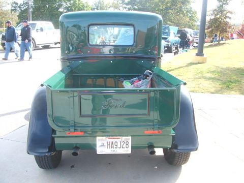 1971 Ford Ranchero - This green Ford pickup truck is seen from the rear, its iconic Ford tailgate emblem and a visible license plate.