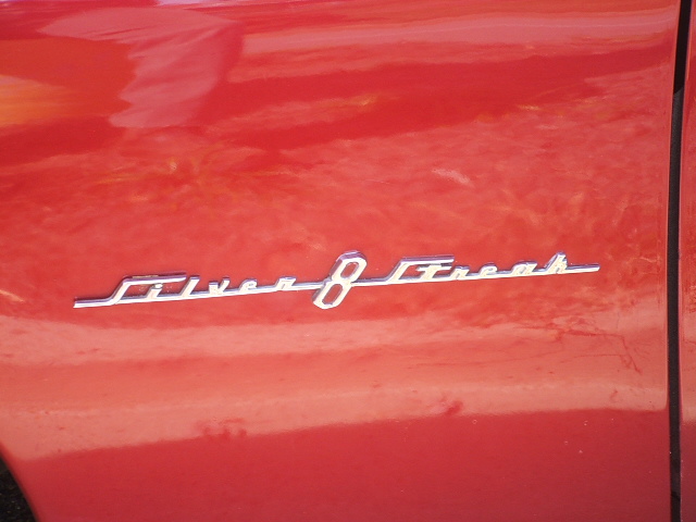 Chrome 'Silver 8' emblem on red vehicle door