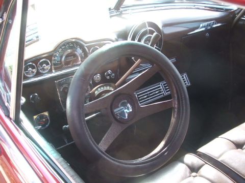 1971 Ford Ranchero - Dashboard and steering wheel of a vintage automobile, a column shifter and round gauges.