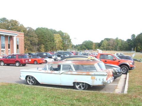 1971 Ford Ranchero - Station wagon with surfboards on roof rack, parked in a lot with other vehicles.