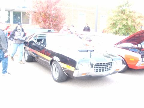 1971 Ford Ranchero - A black Ford Ranchero with a prominent grille and hood scoops is parked outdoors.