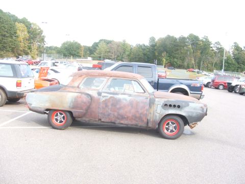 1971 Ford Ranchero - A weathered hot rod coupe sits in a parking lot, surrounded by other vehicles.