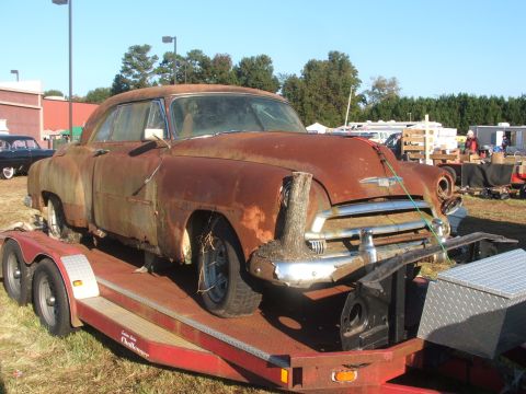 1971 Ford Ranchero - This heavily rusted coupe, likely from the 1950s, is being transported on a trailer.