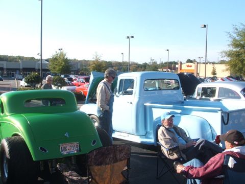 1971 Ford Ranchero - A light blue pickup truck and a green hot rod are parked at an outdoor car show.