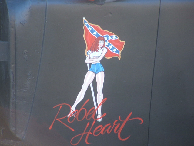 Artwork of a woman with a confederate flag and "Rebel Heart" text on a dark surface