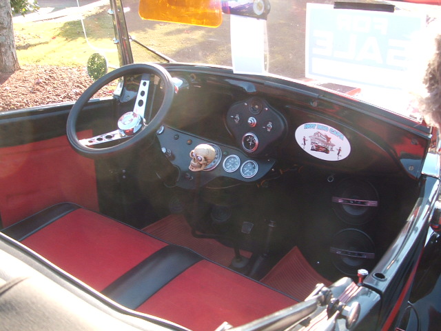 Interior of a hot rod with red seats, skull shifter knob, and custom steering wheel