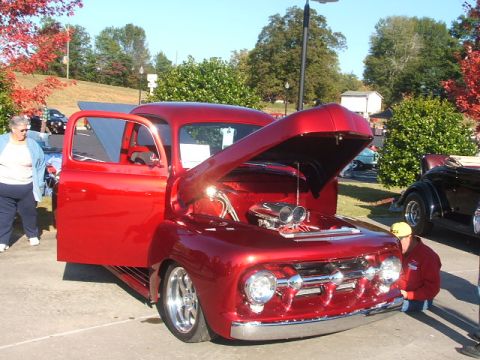 1971 Ford Ranchero - Custom red pickup truck on display, showing off its engine and chrome details.