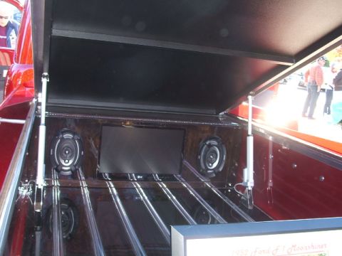 1971 Ford Ranchero - Customized pickup truck bed features speakers and a screen, with a glimpse of the exterior red paint.