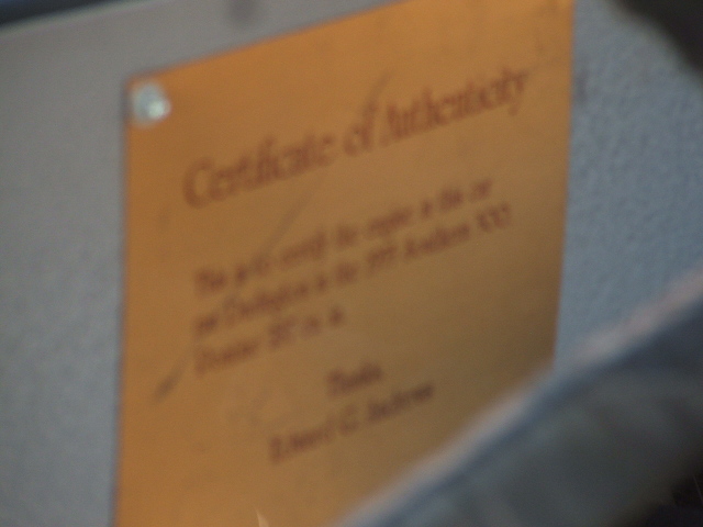 Orange certificate of authenticity with handwritten text and signatures