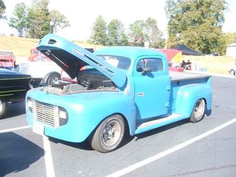 1971 Ford Ranchero - This blue pickup truck, likely from the 1950s, is displayed with its hood open, showing the engine compartment.