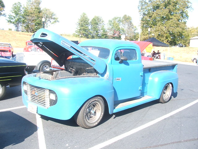 Blue 1950s pickup truck, hood open, front 3/4 view