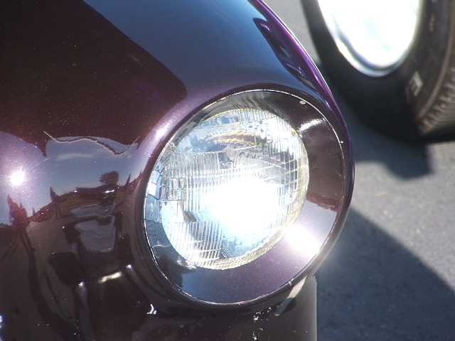 Close-up of 1971 Ford Ranchero headlight and dark purple fender