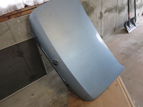2001 Ford Crown Victoria - A light blue car trunk lid with a Mercury emblem is shown indoors, leaning against a concrete wall.