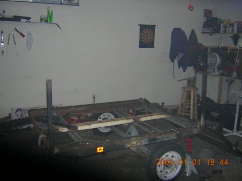 1984 Chevrolet Blazer - A rusty trailer frame sits in a garage, with tools and shelves visible in the background.