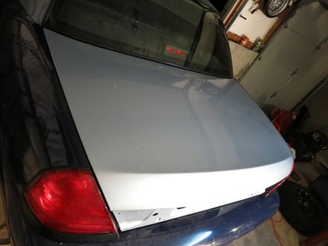 2001 Ford Crown Victoria - The rear of a car, showing a newly painted trunk lid and a red taillight.