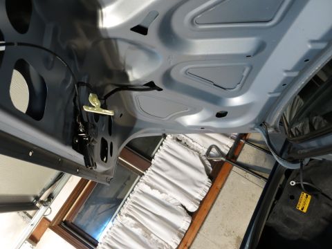 2001 Ford Crown Victoria - Underside of a car hood showing the latch mechanism and structural supports.