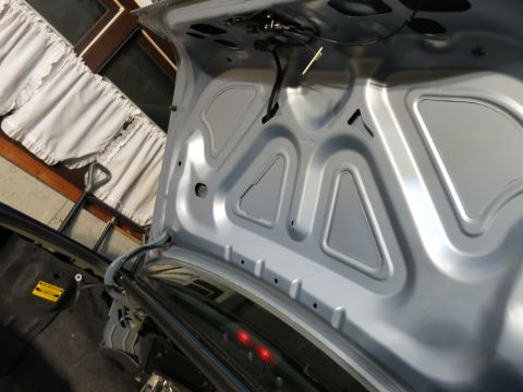 2001 Ford Crown Victoria - The underside of a car's trunk lid, revealing structural supports and the latch assembly.