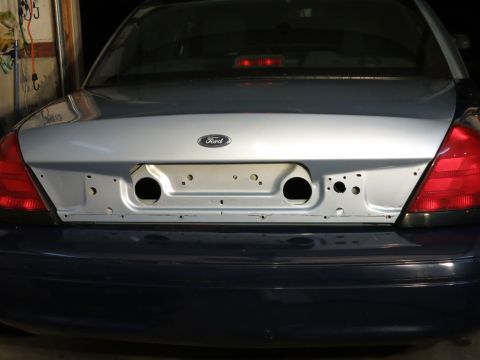 2001 Ford Crown Victoria - The rear of a 2001 Ford Crown Victoria, the Ford emblem and taillights, with the license plate area exposed.