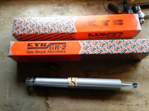 2007 Ford Crown Victoria - Two boxes of KYB GR-2 gas shock absorbers are shown with one shock absorber laid out in front.