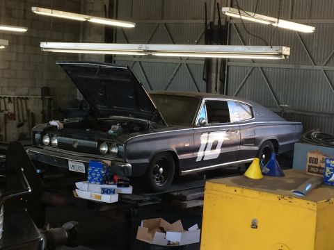 1997 Dodge 3500 - A classic Dodge Charger with its hood open sits in a workshop, ready for maintenance.