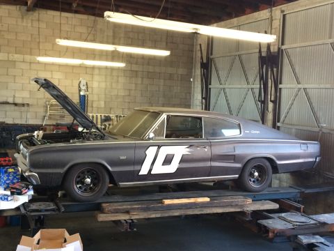 1997 Dodge 3500 - A 1967 Dodge Charger with the hood open is parked on a lift inside a garage.