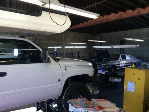 1997 Dodge 3500 - Two vehicles are in a garage, one is a white Dodge 3500 pickup, the other is a dark coupe.