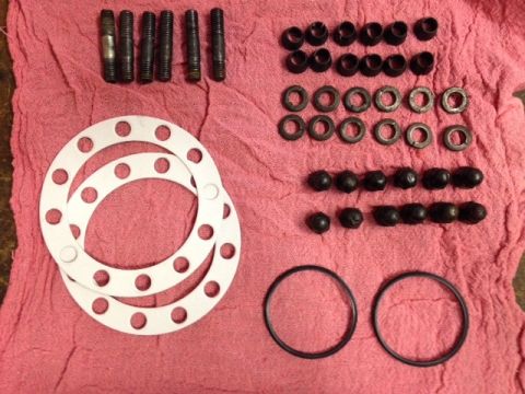 1987 Suzuki Samurai - A collection of engine parts, including studs, gaskets, nuts, and O-rings, laid out on a pink cloth.