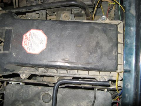 1995 Ford Bronco - Engine air filter housing with a 'STOP DO NOT DISCARD' sticker visible.