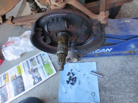 1946 Jeep Willys - Vehicle brake drum assembly disassembled, with parts laid out on paper towels and newspaper.