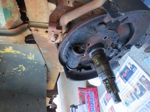 1946 Jeep Willys - Close-up view of a vehicle's wheel cylinder and brake drum assembly, with a newspaper visible in the background.