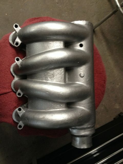 2002 Volkswagen Jetta - A silver intake manifold with four distinct runners is shown from a top-down perspective on a red cloth.