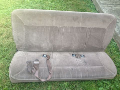 1993 Ford Bronco - A vehicle bench seat with seatbelts is shown outdoors on a grassy area.