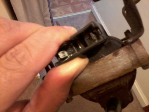 1998 Ford Crown Victoria - A hand manipulates a connector on a vehicle part, with a watermark for SuperMotors.net visible.