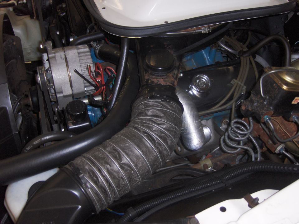 Engine bay detail with alternator and flexible intake hose