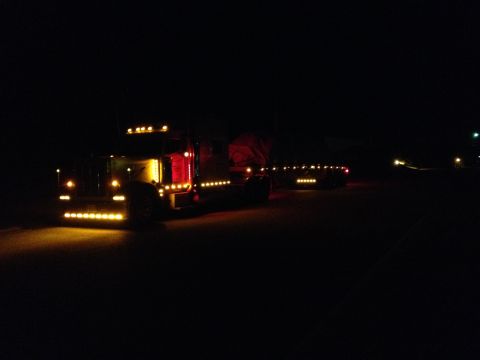 2003 Peterbilt 379 - A semi-truck is seen at night with its grille and side lights illuminated, creating a striking visual display.