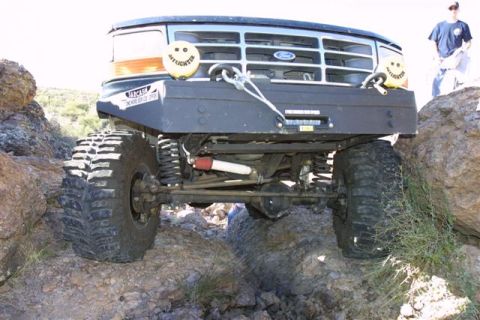 1994 Ford Bronco - This modified Ford Bronco is navigating a rocky trail, its off-road capabilities.