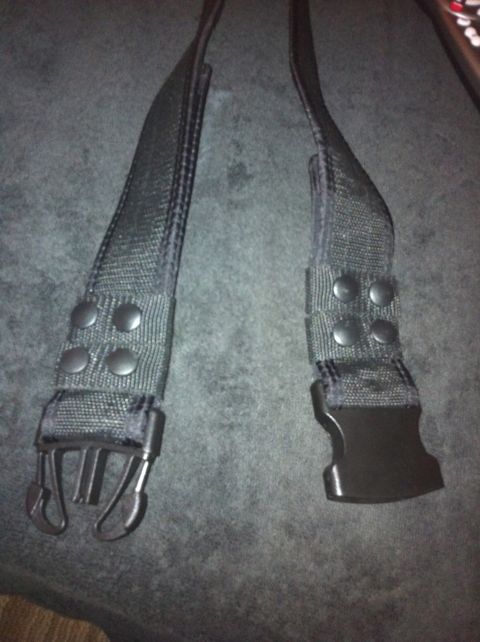 1984 BMW 3 Series - Close-up view of a black seatbelt buckle and strap assembly, showing the buckle mechanism and metal clips.