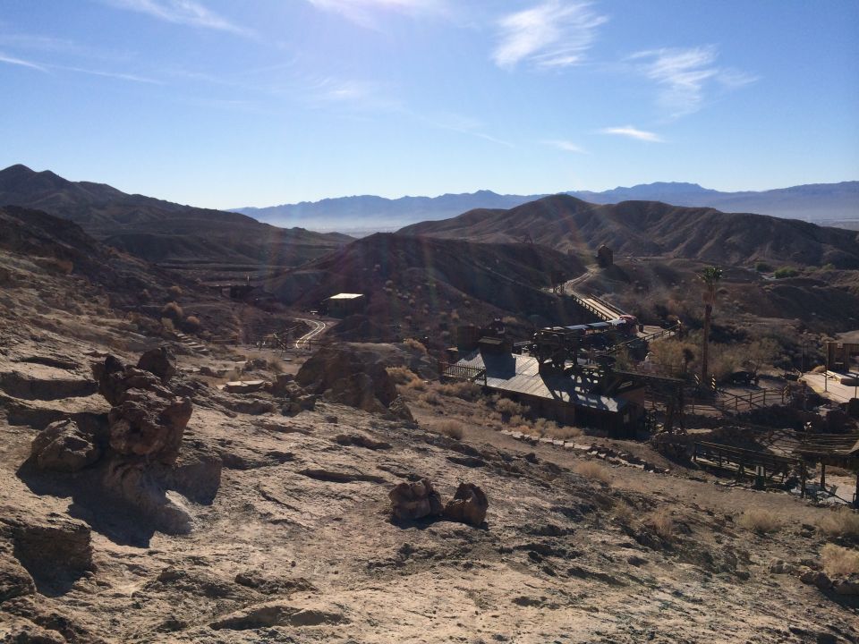 Desert landscape with buildings and mountains under a blue sky