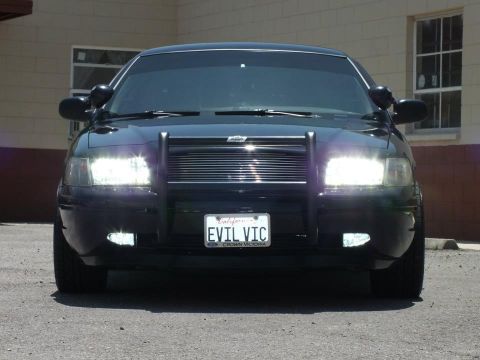 2003 Ford Crown Victoria - Front view of a black Ford Crown Victoria fitted with a police-style push bar and an 'EVIL VIC' California license plate.