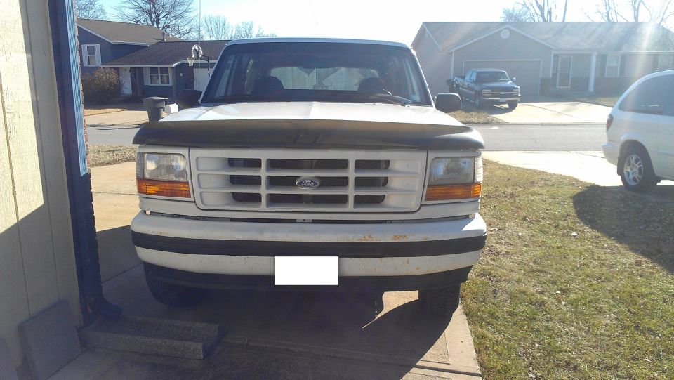 1992 Ford F-150 truck front view, parked in driveway with another truck and van visible