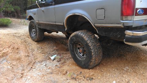 1990 Ford Bronco - This Ford Bronco is shown from the rear quarter on a muddy, off-road trail.