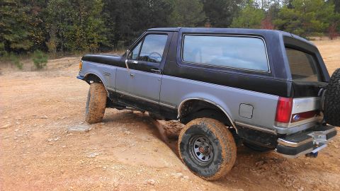 1990 Ford Bronco - This 1990 Ford Bronco navigates a challenging dirt path, its off-road capabilities.